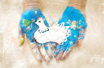 Peace Day. The paper dove on the hands is painted in the color of the globe.