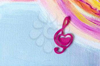 Treble clef with a heart on a beautiful background.Acrylic painting.