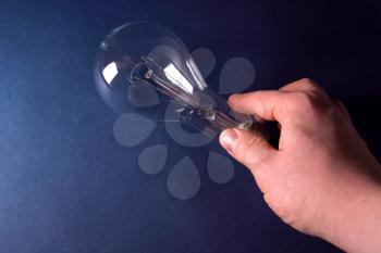 Incandescent lamp in the hand. Lamp is the source of lighting.