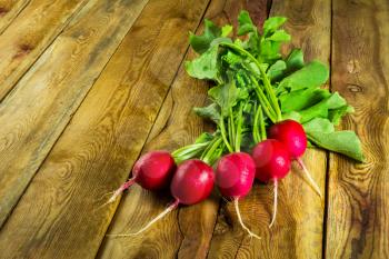 Bunch of fresh radishes on old wooden background, copy space