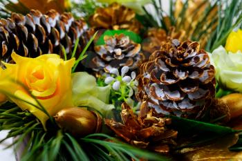Christmas decoration with golden fir cones and silk roses. Christmas party background, selective focus