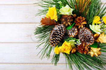 Christmas background with yellow silk roses and golden pine cones. Christmas party decoration. Christmas greeting background. Copy space.