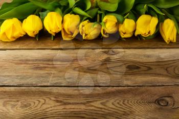 Bunch of yellow  tulips on wooden background, copy space. Spring flowers. Flowers postcard.  Flowers greeting 