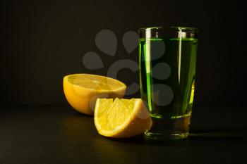 Absinthe and lime on black background. Alcohol drink. Green alcohol drink