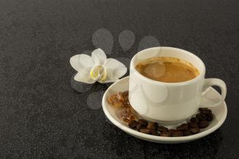 Coffee cup and white orchid on the black background. Cup of coffee. Coffee break. Morning coffee. Coffee cup