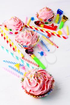 Birthday cupcakes  with pink whipped cream swirl, vertical. Homemade cupcakes served for party. Birthday card background. 
