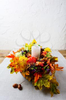 Thanksgiving decoration with silk fall leaves on linen napkin, vertical. Thanksgiving greeting with fall decor. Fall centerpiece. Thanksgiving background. Copy space.