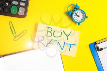 Text sign showing Buy Rent. Business photo showcasing choosing between purchasing something or paying for usage Empty orange paper with copy space on the yellow table