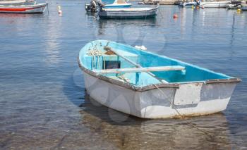 Typical boat above the crystal clear water. The non motorized sea vehicle docks in the shallow area of the seaside. Fishing machinery and mode of transportation