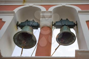 Two large rustic church bells above structure. Building is rusty but paint is still in good condition. Those ringers are still usable and the arc design of the church is a beauty.