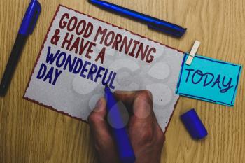 Conceptual hand writing showing Good Morningand Have A Wonderful Day. Business photo text greeting someone in start of the day Man holding marker paper clothespin express ideas wooden table