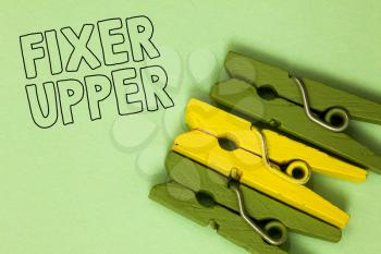 Text sign showing Fixer Upper. Conceptual photo house in need of repairs used chiefly connection with purchase Three green yellow vintage clothespins clear background Holding things