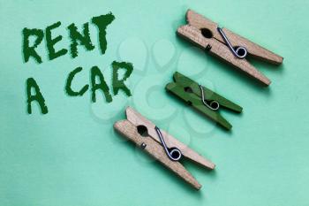 Text sign showing Rent A Car. Conceptual photo paying for temporary vehicle usage from one day to months Three brown green vintage clothespins clear background Holding things