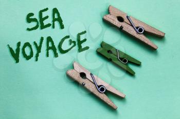 Text sign showing Sea Voyage. Conceptual photo riding on boat through oceans usually for coast countries Three brown green vintage clothespins clear background Holding things