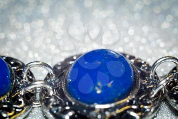 Vintage silver bracelet with natural stone, blue lapis lazuli background.