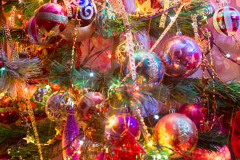Close up of Christmas or New Year fir tree with decorative lights and toys.