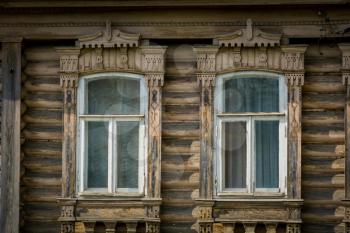 Old wooden house with decorative carved windows background.