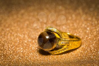 Yellow gold ring decorated with brown tiger eye round bead.