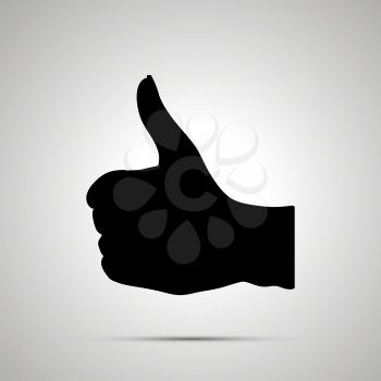 Black silhouette of hand in thumbs-up gesture on white