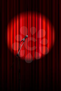 Bright red curtain with shiny microphone in round spotlight lighting, retro theater stage vertical background