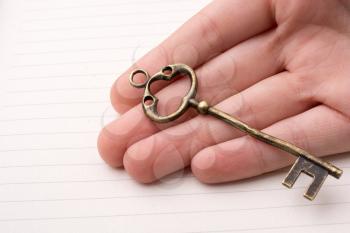 Hand holding a retro styled  golden color   decorative key