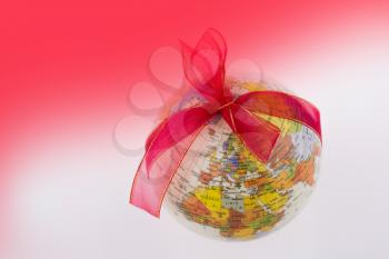 A  globe  with a ribbon on a red and white background