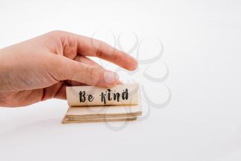 Hand holding a notebook with  BE KIND wording