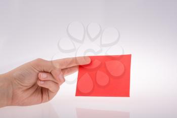hand holding a red note paper  on white background