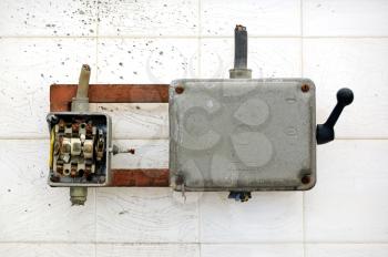 Broken industrial electrical switch and paint stained wall.