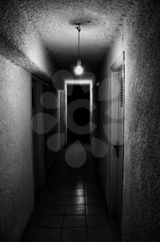 Dim light glowing in dark underground corridor.