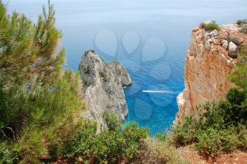 Panoramic view to the ionian sea from a mountain near Keri in the island of Zakynthos, Greece. Small boat passing through the Myzithres rocks below.