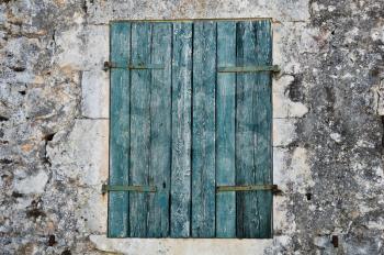 Stone wall and blue window shutter. Traditional house in Zakynthos, Greece.