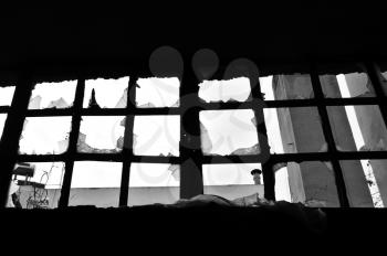 Broken window in abandoned factory. Black and white.