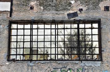 Concrete wall and view from broken window of abandoned factory.