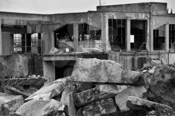 Abandoned marble processing factory and pile of granite slates. Black and white.
