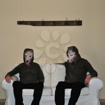 Two human figures with dog animal mask sitting on sofa couch.