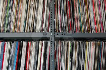 Vinyl music records storred on metal shelves.