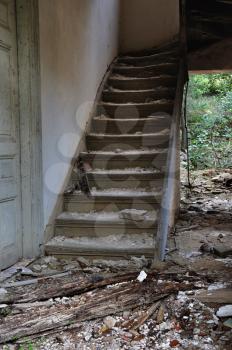 Old wooden staircase and dirty floor in abandoned house interior.