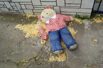 Torn teddy bear on the sidewalk. oy resembling crime victim in murder scene.