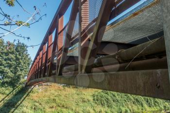 A metal walking bridge spans the Green River in Washington State. Closeup shot.
