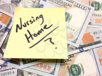 American cash money and yellow paper note with text Nursing Home with question mark in black color aerial view