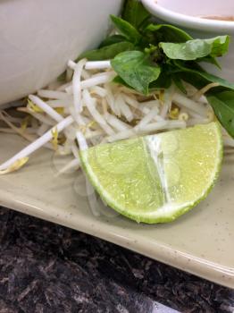 Lime slice bean sprouts and basil condiments for vietnamese pho