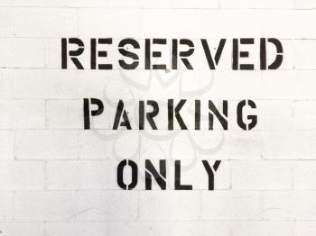 Reserved parking only sign black letters on white background in parking garage