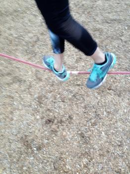Tightrope slack line walker athletic sneakers at park balance