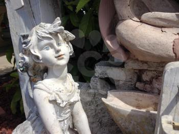 Girl child garden statue smiling on a sunny day