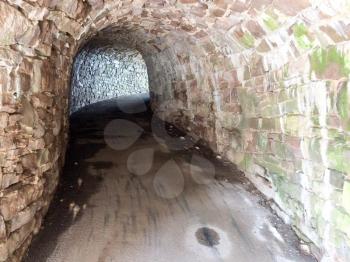 stone tunnelway walking path underground with light shining