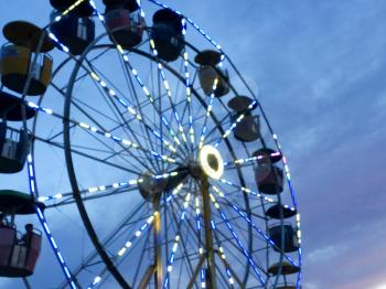 ferris wheel at fairgrounds at sunset with colorful sky