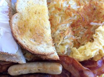 classic american breakfast egg bacon sausage toast on white plate