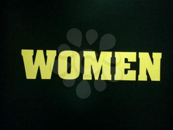yellow sign women text restroom on black background