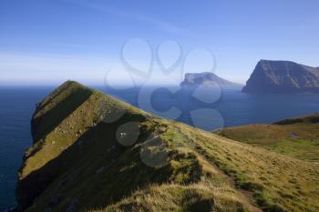 Kallur lighthouse hiking area showing Kunoy and Vidoy islands on a bright sunny day with blue sky